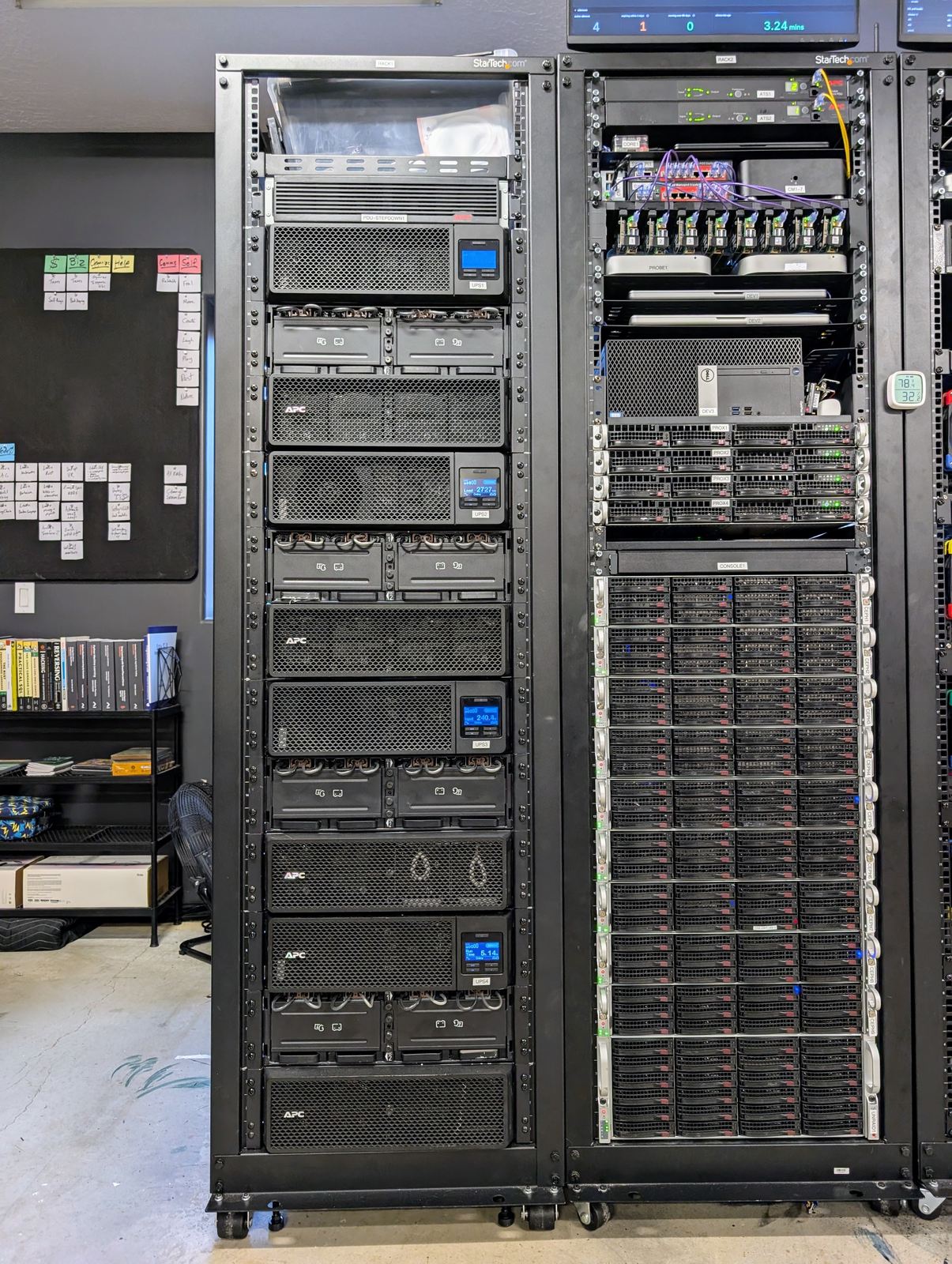 A rack of uninterruptible power supplies and their external battery packs, standing beside a rack of servers