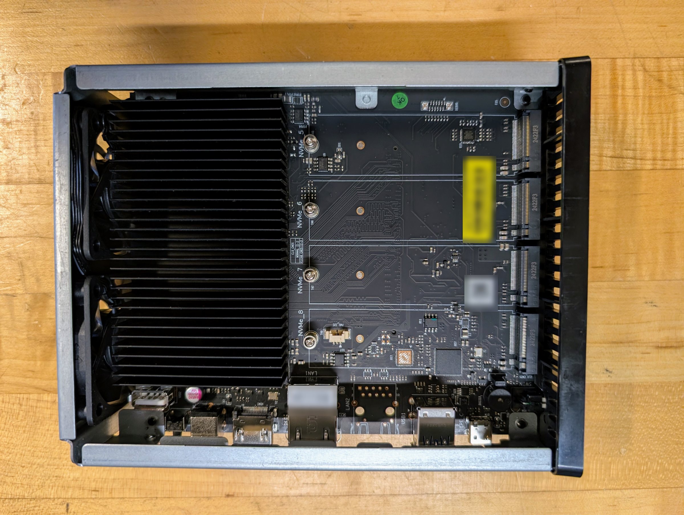 The other side of the NAS board: a large black heatsink on the left and four empty drive slots on the right.